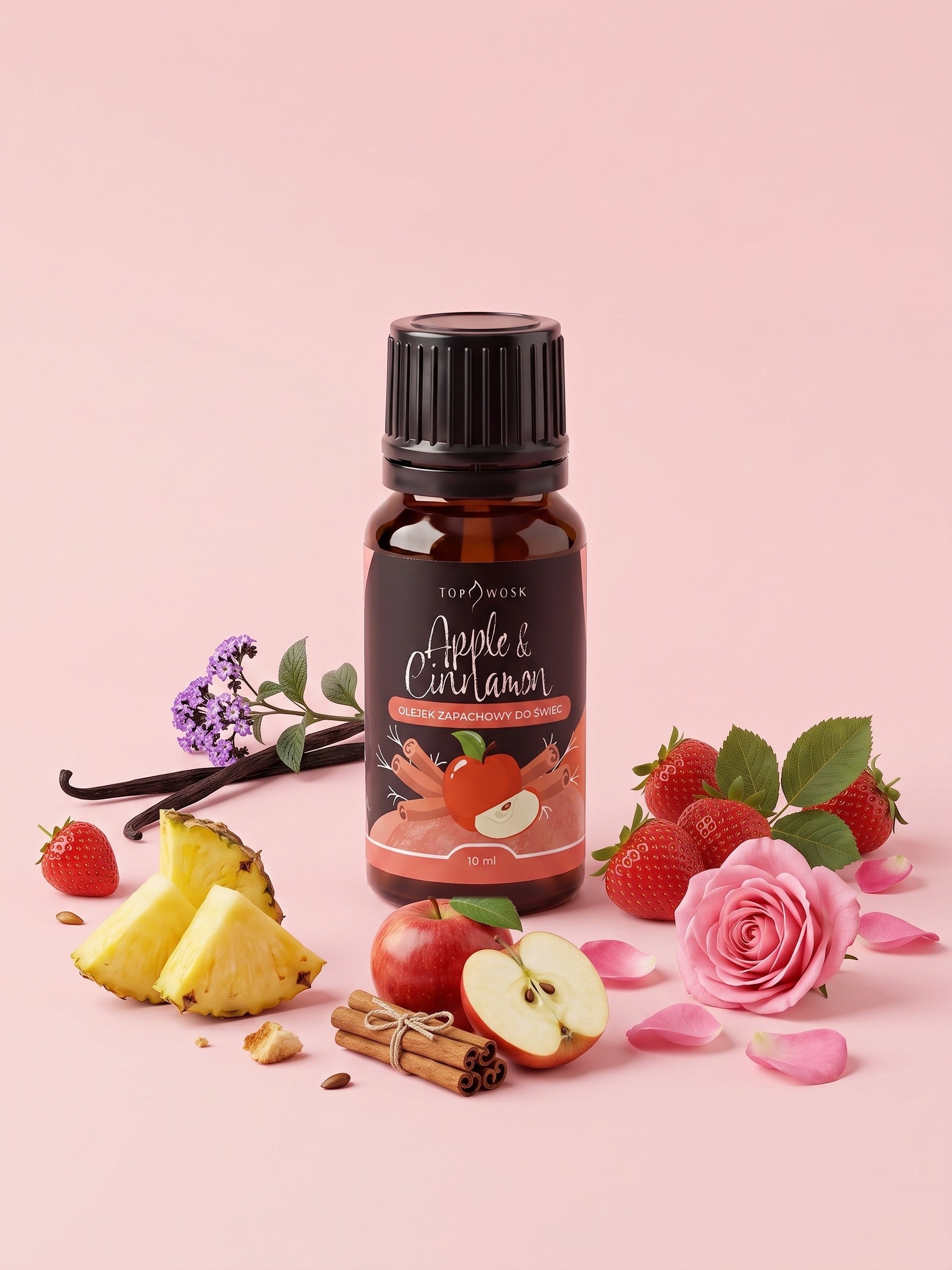 Olejek zapachowy do świec Apple&Cinnamon w butelce 10 ml otoczonej czerwonym jabłkiem, laskami cynamonu, ananasem, truskawkami, różą i heliotropem