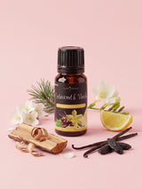 Olejek zapachowy do świec Cedarwood & Vanilla w butelce 10 ml otoczonej drewnem cedrowym, laskami wanilii, fasolą tonka, gałązką sosny, jaśminem i frezją