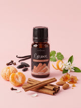 Olejek zapachowy do świec Cynamon w butelce 10 ml otoczonej laskami cynamonu, mandarynką, migdałami, goździkami, kwiatem pomarańczy i laskami wanilii