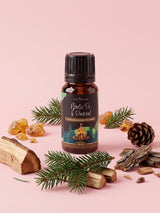 Olejek zapachowy do świec Nordic Fir & Firewood w butelce 10 ml otoczonej gałązkami jodły, polanami drewna, szyszką, korą i bursztynem